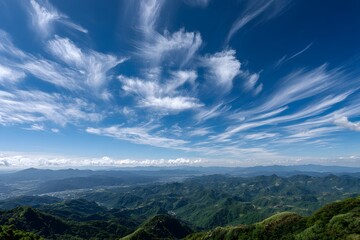 Green mountains under wispy clouds landscape