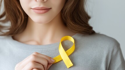 Close-up of young woman attaching yellow ribbon, Setembro Amarelo concept