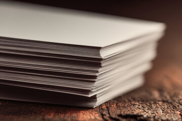 set of elegant business cards lying on richly textured wooden table featuring ar names displayed in blurred white