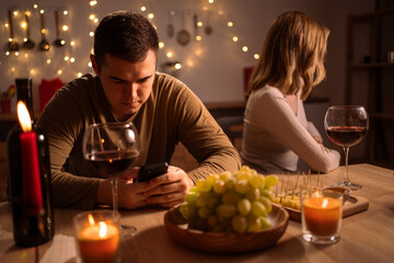 Caucasian couple has romantic dinner at home, date with addicted busy man who using smartphone ignoring upset woman. Concept of quarrel, crisis relationship and conflict