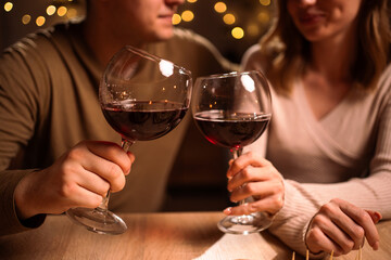 Young Couple in love drinking red wine. Romantic date at night. Toast. Dinner for couple on Valentine's day.