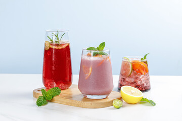 Refreshing Summer Fruit Drinks with Herbs and Citrus on White Table