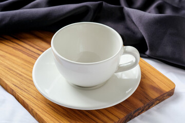 Empty White Coffee Cup with Saucer on Wooden Board