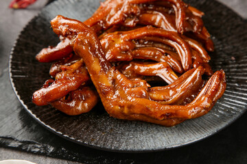 Marinated Duck Feet with Spicy Soy Sauce Glaze on Wooden Plate - Traditional Asian Snacks