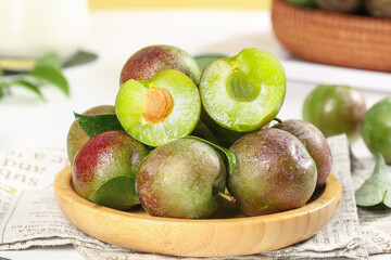 Fresh Sweet Plums in Wooden Bowl - Ripe Green Fruit Ready for Eating or Cooking
