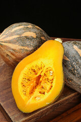 Fresh Cut Pumpkin with Orange Flesh and Seeds on Wooden Board - Autumn Harvest Vegetable