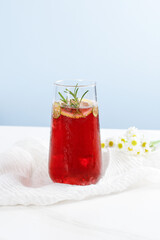 Fresh Red Grape Juice Cocktail with Rosemary Garnish on White Table - Summer Drink Scene