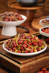 Multiflavored Fried Peanuts Peas Small Fish Snack Mix in White Bowls on Wooden Table