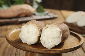 Fresh White Potatoes Cut in Half on Wooden Plate Showing Natural Interior Texture
