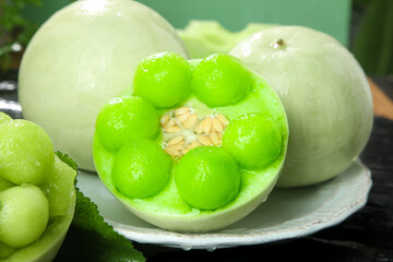 Fresh Chayote Squash Cut Open Showing Green Flesh and Seed on White Plate