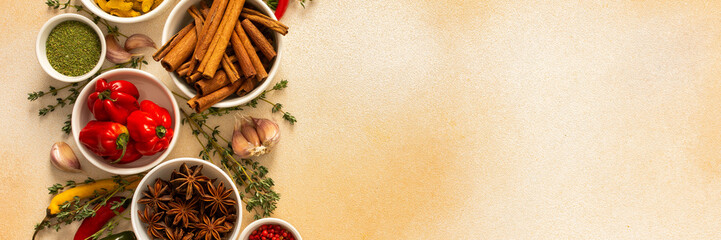 A warm display of spices and herbs on a beige background, each adding rich aromas and flavors, perfect for enhancing recipes, banner