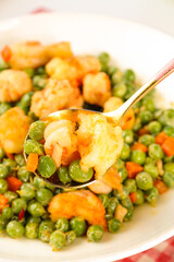 Sautéed Shrimp and Peas Dish on White Plate with Serving Spoon - Healthy Seafood Meal