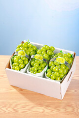 Fresh Green Grapes in White Box on Wooden Table with Natural Lighting