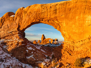 Winter sunrise's soft light illuminates Turret Arch, captured through North Window in Arches National Park, Moab, Utah. © Nick Monitello