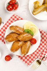 Crispy Baked Chicken Wings with Salt Seasoning and Fresh Vegetables on White Background