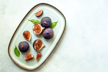 Fresh ripe figs on a plate top view on a gray background