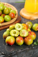 Fresh Cut Chinese Plums with Exposed Flesh and Pits on Dark Slate Kitchen Surface