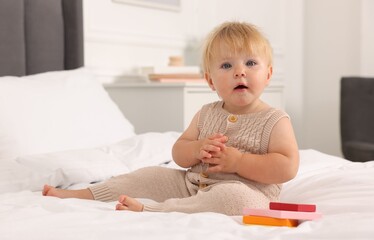 Fototapeta premium Cute baby with toy sitting on bed at home