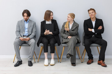 People waiting in queue on chairs indoors
