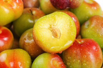 Fresh Cut Plum Demonstration Showing Yellow Pulp Interior with Water Droplets on Colorful Stone Fruit