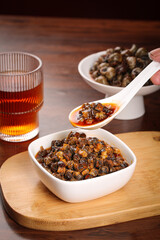 Spicy Braised Conch Meat in Sauce Served on Wooden Board with Tea - Traditional Asian Seafood Cuisine