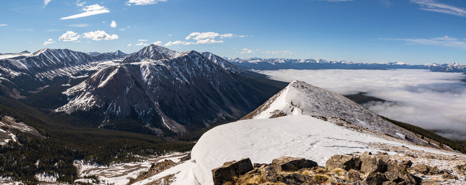 This scenic mountain panorama features Jenkins Mountain, a 13er in the Colorado Sawatch Range, rising above a cloud-filled Taylor Park.