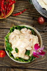 Fresh Diced Chicken Served with Lettuce Garnish and Red Chili Peppers on Rustic Wooden Table