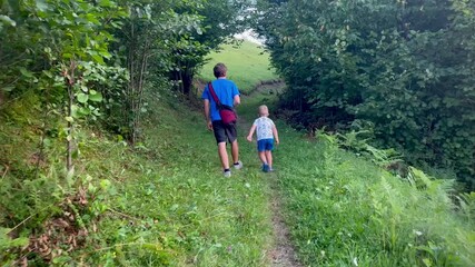 Father and son walking together on a forest path