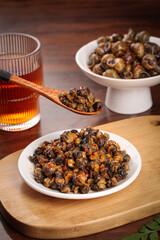 Spicy Stir-Fried Whelk Seafood Dish Traditional Asian Cuisine with Tea Glass