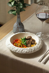 Beef kufte with hummus and roasted vegetables in white bowl