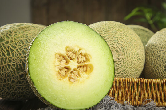 Fresh Honeydew and Cantaloupe Melons Cut in Half Showing Green Flesh and Seeds in Rustic Basket