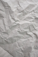 Gray recycled  paper sheet crumpled with shadowed wrinkles, soft focus close up, abstract texture