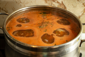 Boiling tomato soup with bubbles and foam, soft focus close up