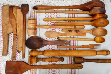 Many wooden spoons and spatulas on a white canvas towel