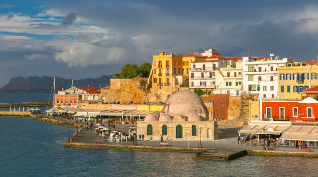 Waterfront view of the Venetian Harbor in Chania on Crete island in Greece with the Mosque of the Janissaries and colorful buildings.