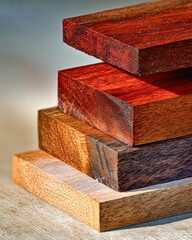 A close-up of various wooden planks stacked together, showcasing different hues and textures, highlighting the beauty of natural wood.