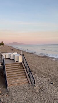 Peaceful sandy beach in California with stairs leading to the ocean shore at sunset in Santa Barbra creating a serene coastal vacation and travel background.