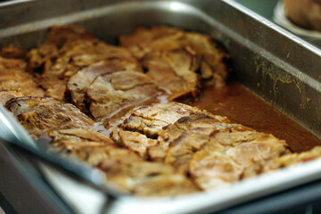 Juicy oven-roasted pork tenderloin in a baking tray with savory gravy