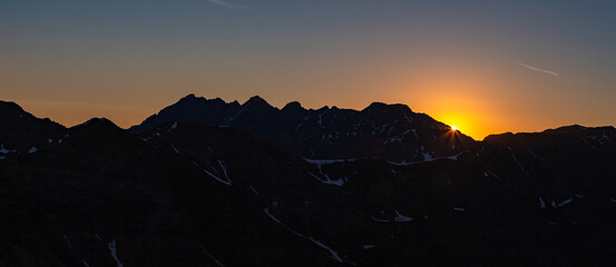 Panorama of the sun rising just above the ridge of the Pyramid massif in the Elk Range mountains of Colorado.