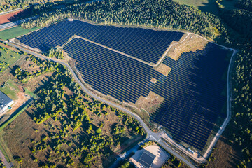 Aerial view of huge Solar Fram beside Highway In Europe - Powering EV cars with Green Energy