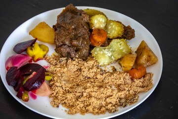 The most authentic and original Brazilian rustic pot roast, carne de panela,  with woody sauce and vegetables, served with farofa and salad