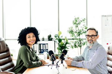 Professional coworkers recording podcast together in modern office setting promoting collaboration and teamwork