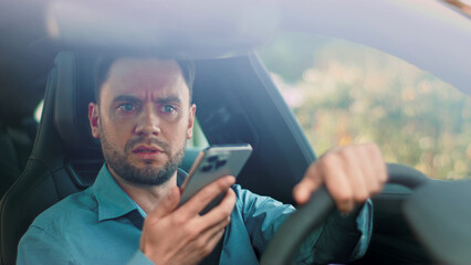 The serious issue of distracted driving caused by mobile phone use while driving a vehicle. Visibly concerned driver is using a smartphone behind the wheel of their vehicle, displaying risky behavior