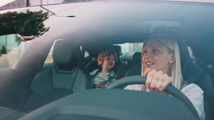 A mother joyfully drives with her young child on an autumn road trip, embracing family bonding. A dedicated mother safely drives while her happy child enjoys the ride, highlighting family dynamics