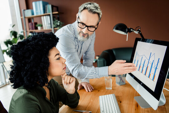 Professional colleagues collaborating on a project with analysis and brainstorming in a contemporary office environment