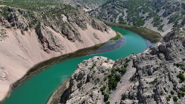 Aerial view where rivers Krnjeza and Krupa merge. Aerial shots of winding Zrmanja river cutting through deep canyon, lush spring colors and remote paths