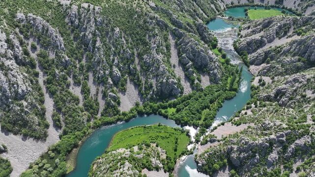 Aerial view where rivers Krnjeza and Krupa merge. Aerial shots of winding Zrmanja river cutting through deep canyon, lush spring colors and remote paths