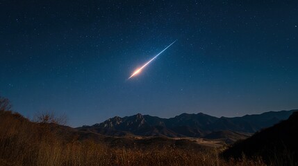 A brilliant meteor streak with a glowing tail in a star-filled night sky.