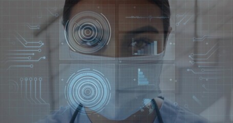 Analyzing doctor with stethoscope wearing surgical mask monitoring data panels in hallway