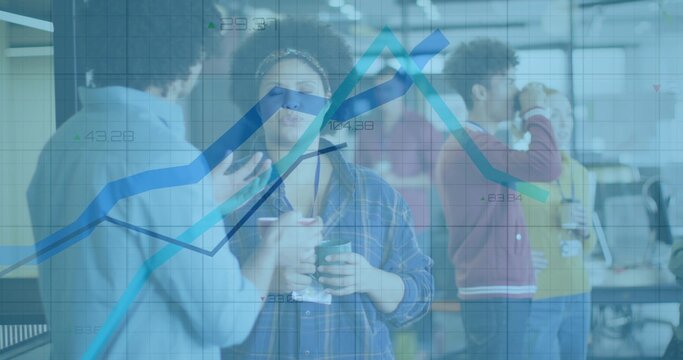 Chatting coworkers holding coffee mugs and checking laptop at office break area, with data chart